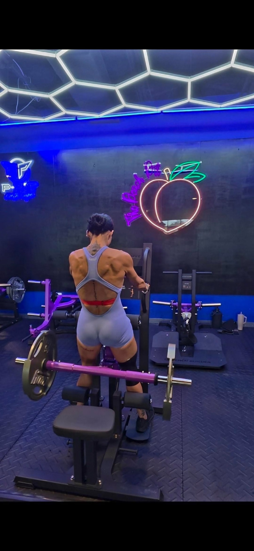 Training on the Peach Builder machine under the neon peach sign